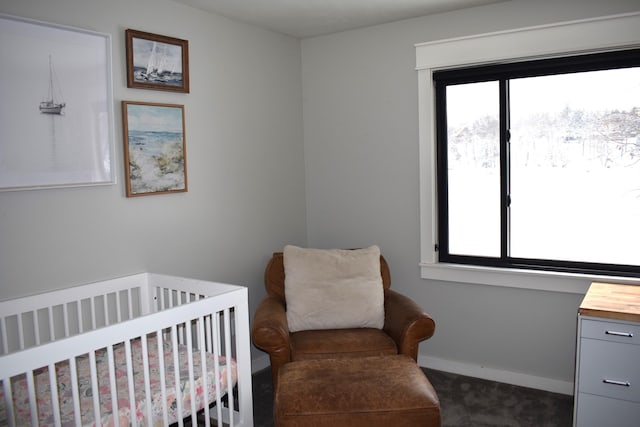 carpeted bedroom featuring a nursery area