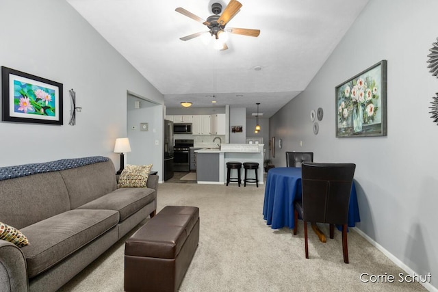 carpeted living room featuring sink, ceiling fan, and vaulted ceiling