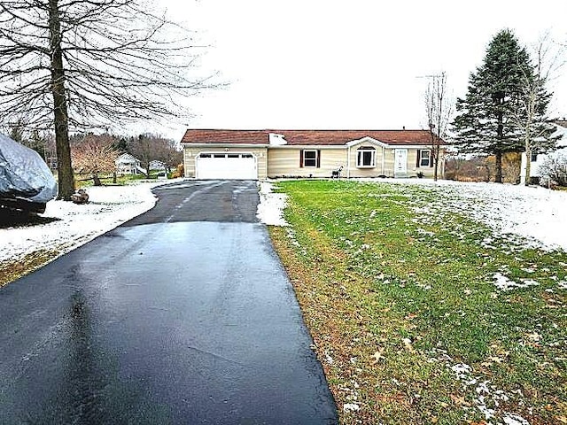 view of front of property with a garage, aphalt driveway, and a front yard