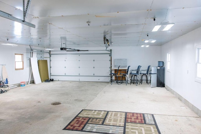 garage featuring fridge and a garage door opener