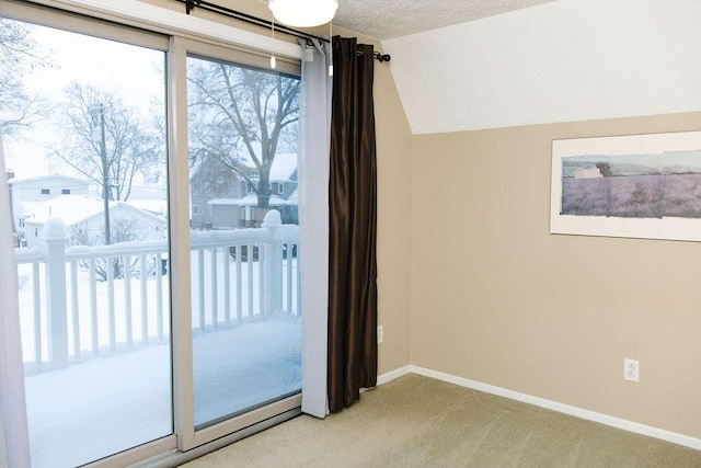 entryway with lofted ceiling, light colored carpet, and a textured ceiling