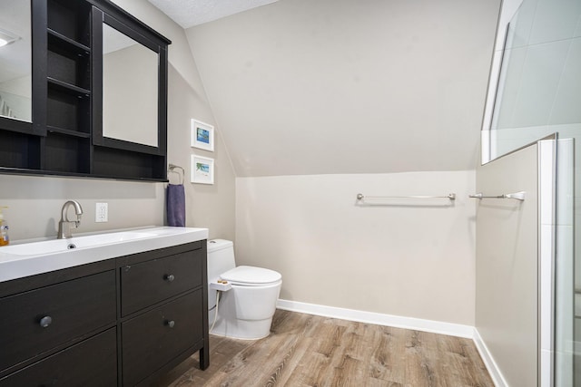 bathroom featuring lofted ceiling, vanity, toilet, walk in shower, and hardwood / wood-style flooring