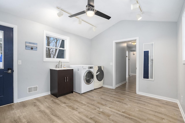 laundry room with washing machine and dryer, cabinets, light hardwood / wood-style floors, sink, and ceiling fan