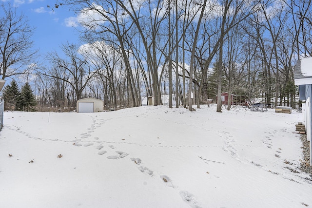 snowy yard with a garage and a storage unit