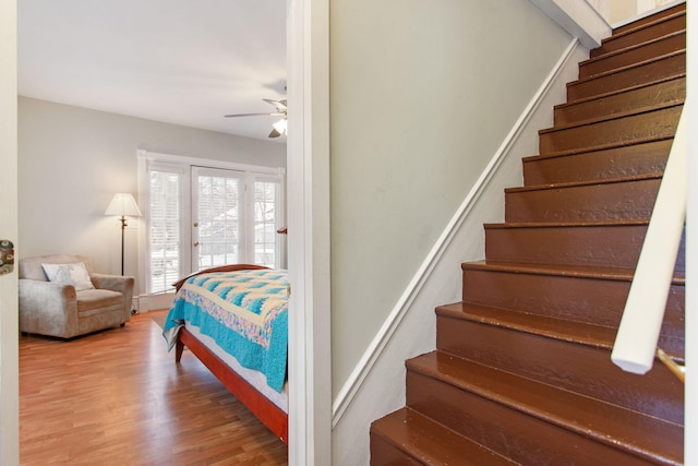 staircase featuring hardwood / wood-style floors and ceiling fan