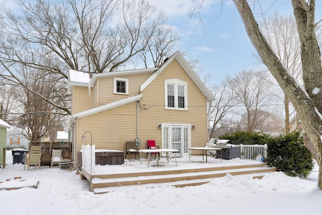 snow covered house featuring a hot tub