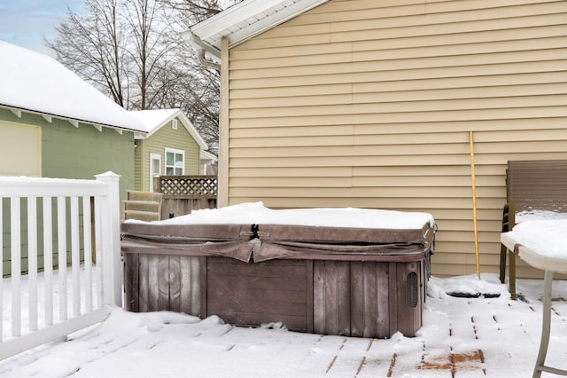 snow covered deck with a hot tub