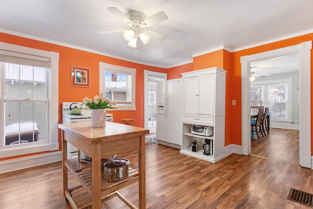 office with dark hardwood / wood-style flooring, a wealth of natural light, and ornamental molding