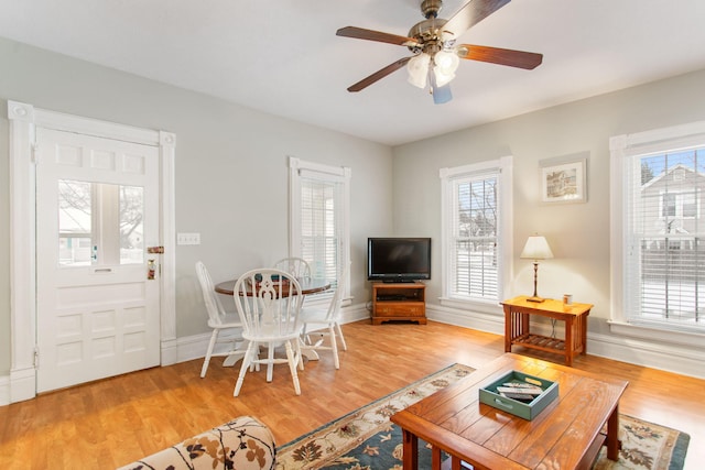 living room featuring ceiling fan, plenty of natural light, and hardwood / wood-style flooring