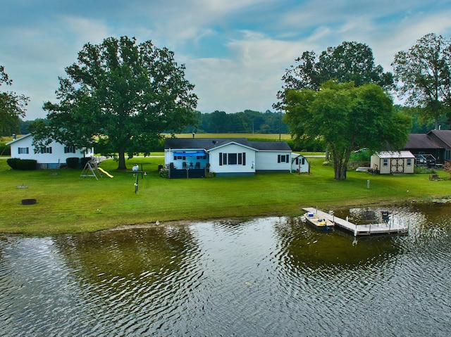 rear view of house with a yard and a water view