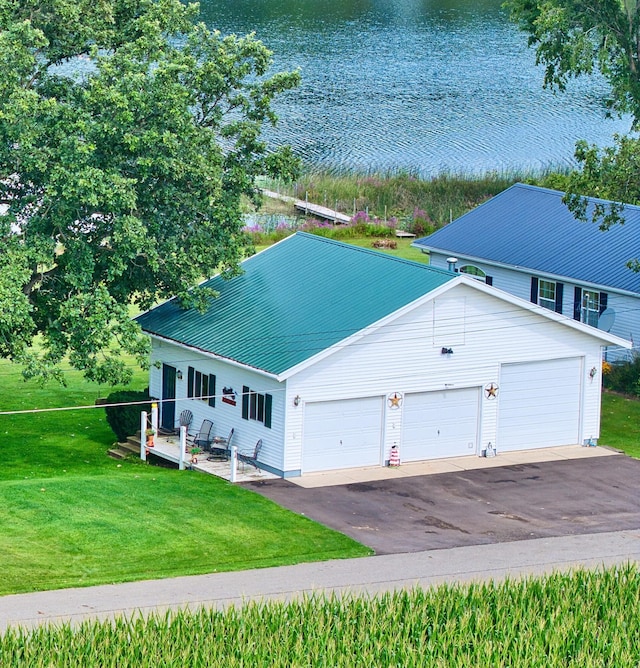 view of front facade featuring a garage, a water view, and a front yard