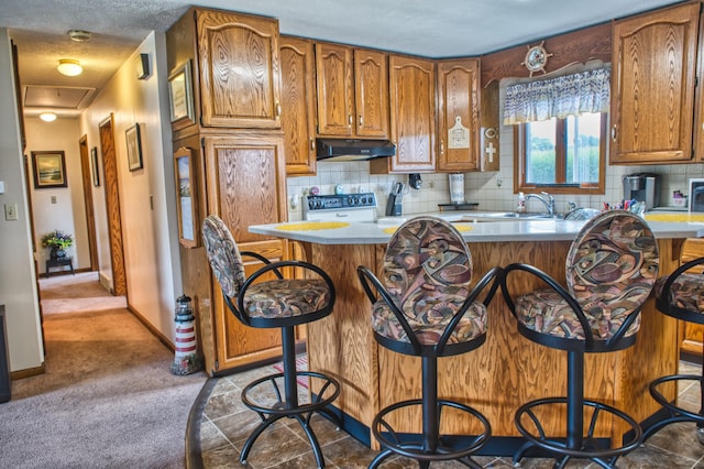 kitchen with a center island, high end white range oven, a kitchen breakfast bar, sink, and tasteful backsplash