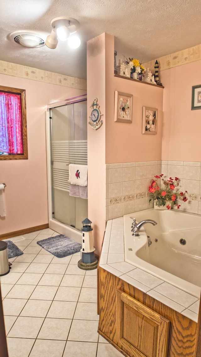 bathroom with plus walk in shower, a textured ceiling, and tile patterned floors