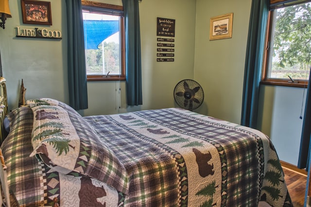 bedroom with hardwood / wood-style floors and multiple windows