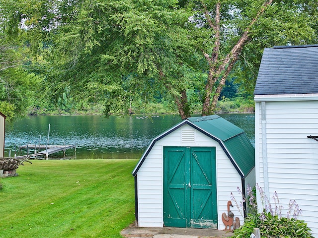 view of outbuilding featuring a lawn and a water view