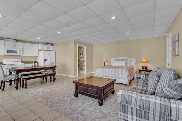 bedroom featuring light tile patterned floors, white refrigerator with ice dispenser, and a paneled ceiling