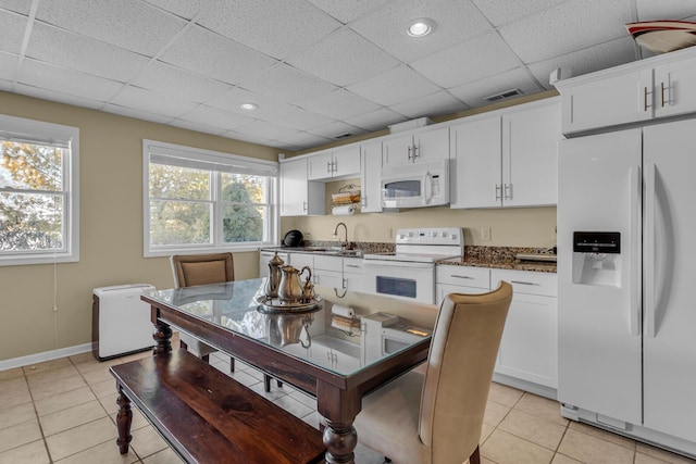 kitchen with white cabinetry, sink, white appliances, and a drop ceiling