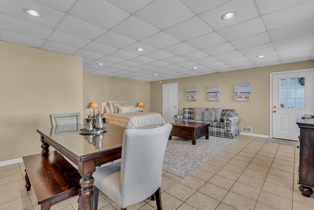 bedroom featuring light tile patterned flooring and a drop ceiling