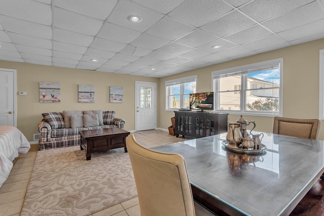 dining space with a drop ceiling and tile patterned flooring