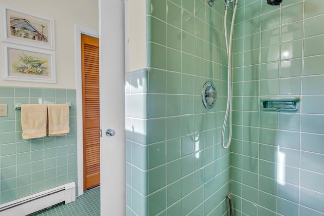 bathroom with baseboard heating, tile patterned flooring, a tile shower, and tile walls