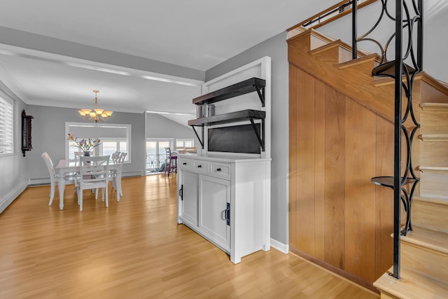 dining room with light wood-type flooring, vaulted ceiling, crown molding, and a chandelier