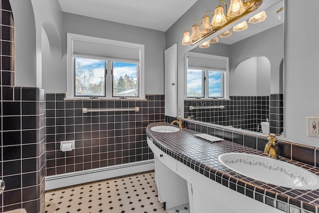 bathroom with baseboard heating, tile walls, and vanity