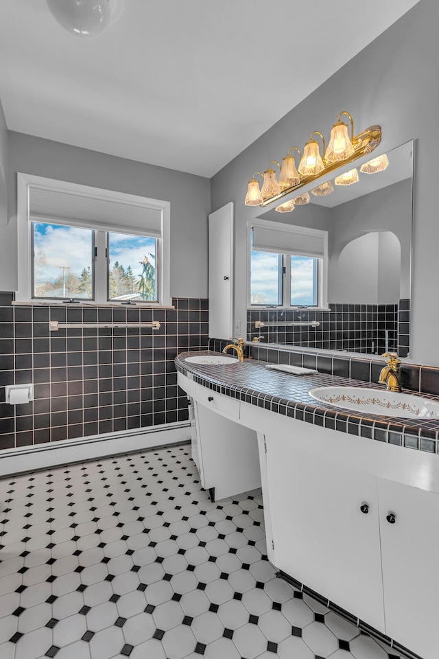 bathroom featuring tile patterned flooring, vanity, tile walls, and plenty of natural light