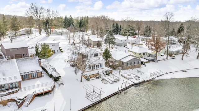 snowy aerial view with a water view