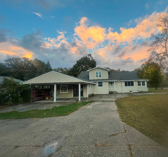 view of front of house featuring a carport and a yard