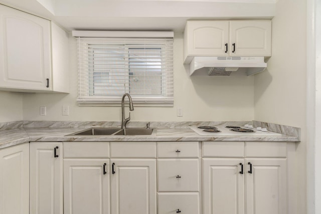 kitchen with under cabinet range hood, white electric cooktop, light countertops, white cabinets, and a sink