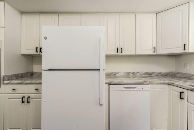 kitchen featuring white appliances, light countertops, and white cabinetry