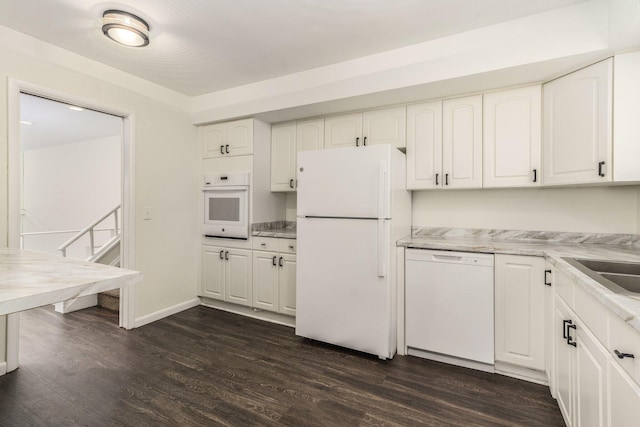 kitchen with white appliances, white cabinets, and dark wood-style flooring