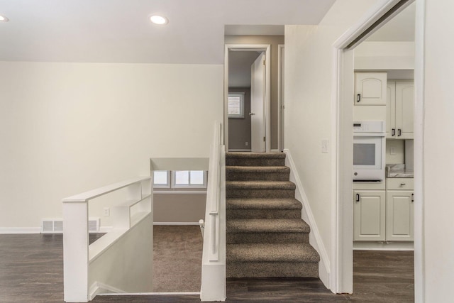 stairs featuring visible vents, recessed lighting, wood finished floors, and baseboards