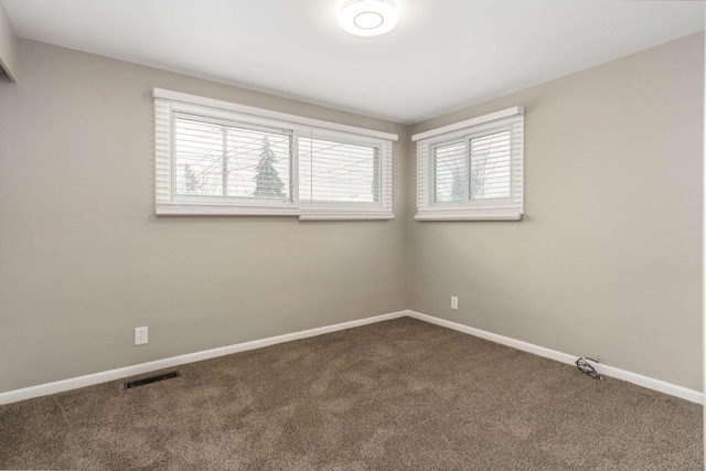 carpeted empty room with visible vents and baseboards