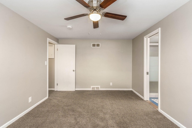 unfurnished room with visible vents, a ceiling fan, baseboards, and carpet floors