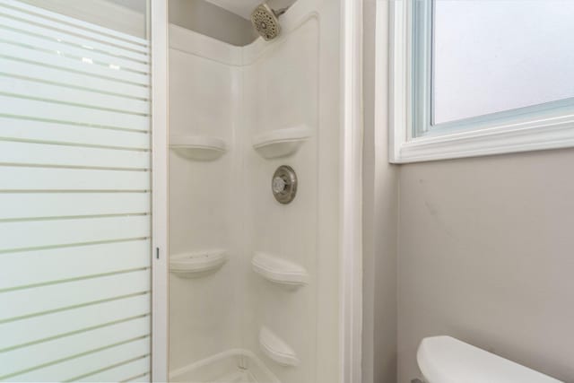 bathroom featuring toilet and walk in shower