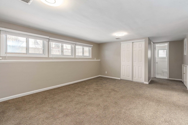 unfurnished bedroom with a closet, visible vents, baseboards, and carpet