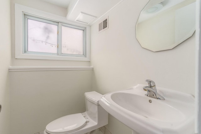 bathroom with visible vents, toilet, and a sink