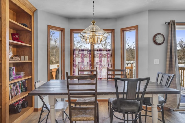 dining area featuring a wealth of natural light, dark hardwood / wood-style floors, and a chandelier