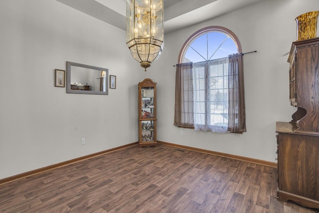 interior space featuring dark wood-type flooring and an inviting chandelier