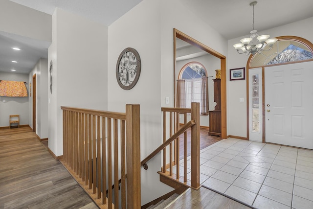 tiled foyer featuring a healthy amount of sunlight and a notable chandelier