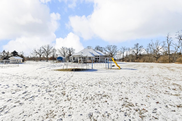 snow covered playground featuring a trampoline