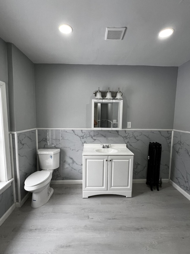 bathroom featuring toilet, vanity, and hardwood / wood-style flooring