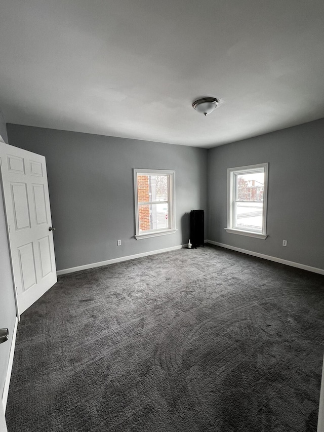 spare room with dark carpet