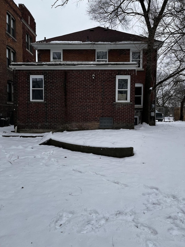 view of snow covered back of property