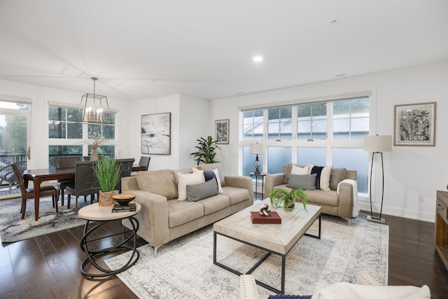 living room with dark hardwood / wood-style floors and an inviting chandelier