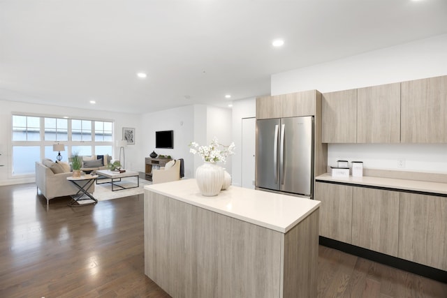 kitchen with built in fridge, dark hardwood / wood-style floors, a kitchen island, and light brown cabinets