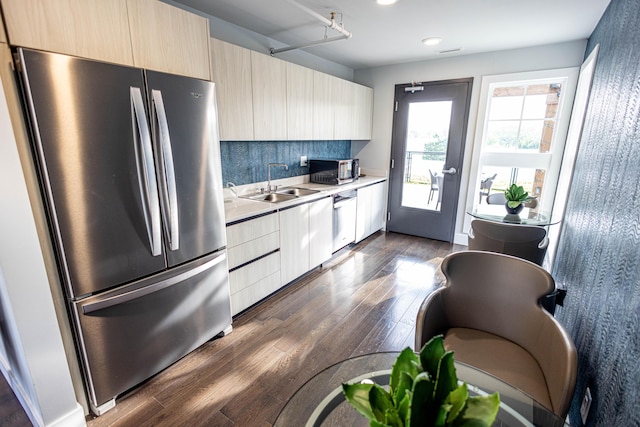 kitchen featuring sink, light brown cabinets, dark wood-type flooring, stainless steel appliances, and backsplash