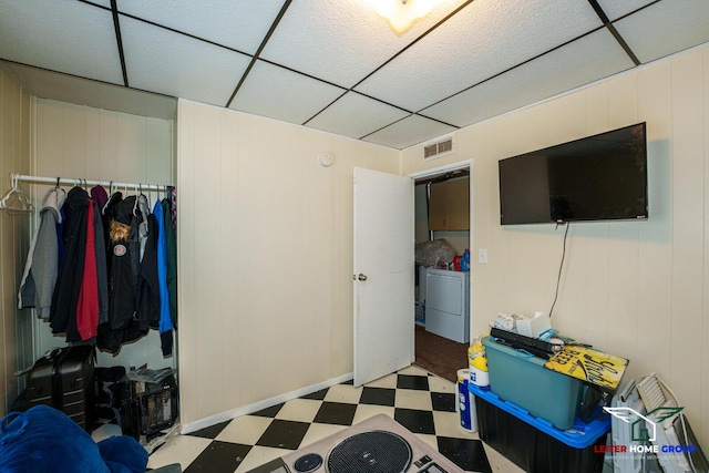 interior space with a closet, a drop ceiling, and independent washer and dryer