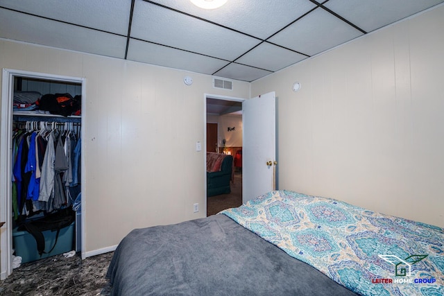 bedroom featuring a paneled ceiling and a closet